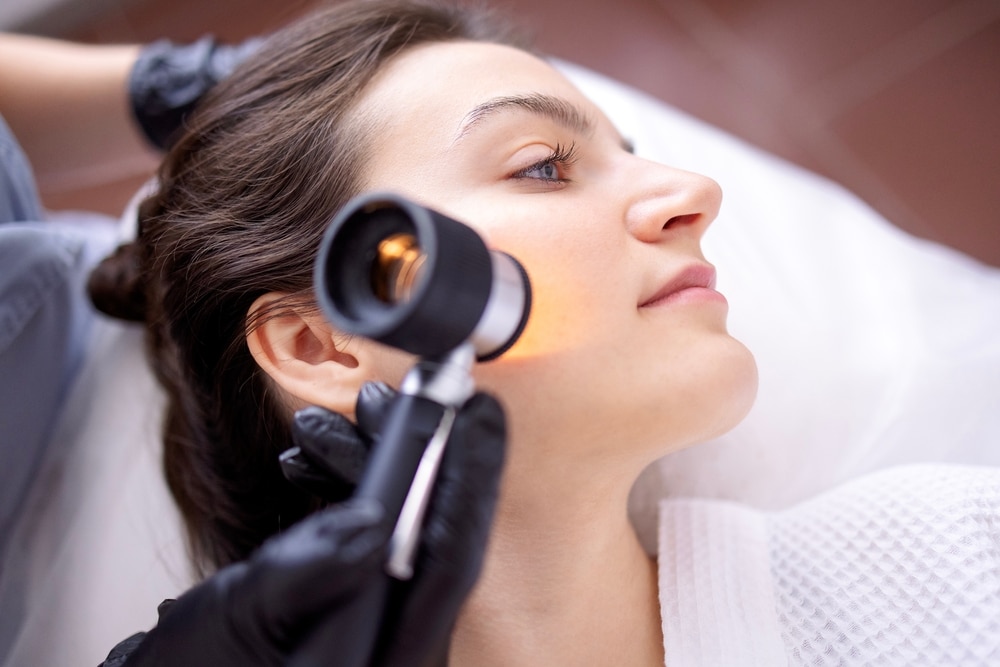 Doctor examines a woman's mole before dermatologic surgery
