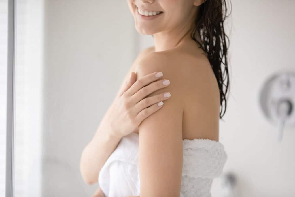Woman smiling touching her arm after cyst removal in Lubbock, TX